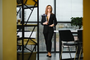 Confident business woman stands in the office