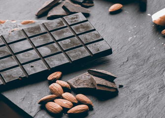 
Handmade raw vegan chocolate with almonds on dark graphite background
