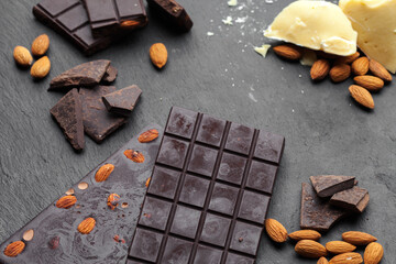 
Chocolate and cocoa concept. Cocoa butter and broken chocolate on black background, top view, copy space