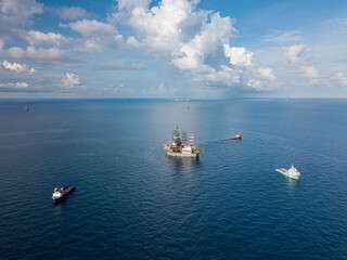 Offshore drilling rig (jack up rig) and tow vessels during the rig move operation in the middle of...