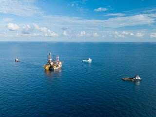 Offshore drilling rig (jack up rig) and tow vessels during the rig move operation in the middle of...