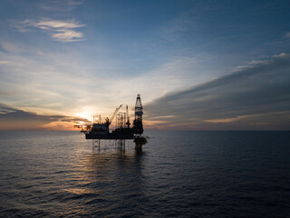 Aerial view offshore drilling rig (jack up rig) at the offshore location during sunset