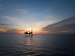 Aerial view offshore drilling rig (jack up rig) at the offshore location during sunset