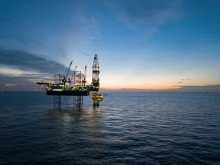 Aerial view offshore drilling rig (jack up rig) at the offshore location during sunset