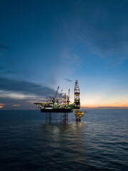 Aerial view offshore drilling rig (jack up rig) at the offshore location during sunset