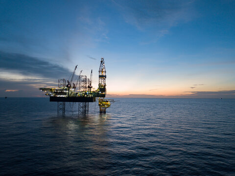 Aerial view offshore drilling rig (jack up rig) at the offshore location during sunset