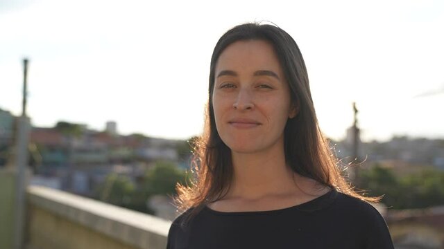 Close-up portrait of nice-looking white woman. Woman looking confident into camera on a summer sunset.Female portraits. 
