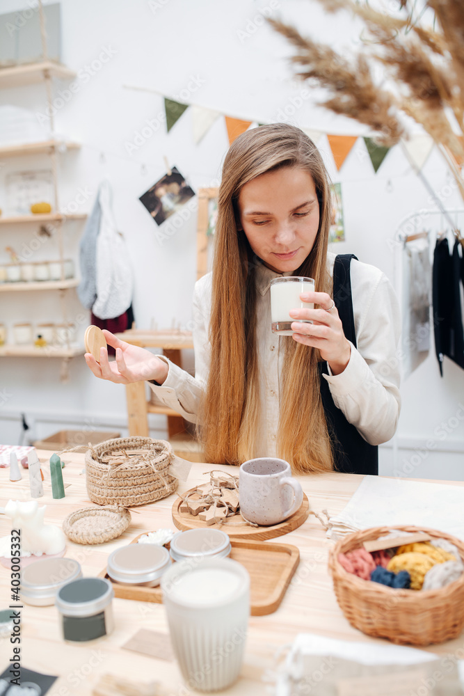 Wall mural curious young woman in an ecological shop choosing between various cosmetic products. standing in fr