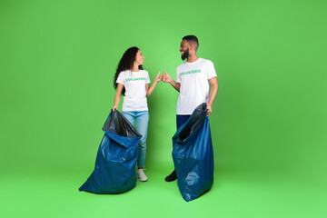 Volunteers With Garbage Bags Standing On Green Background, Gesturing Thumbs-Up