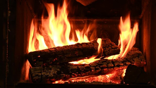Warm cozy burning fire in a brick fireplace, close-up shot 4k.