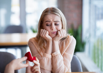 Bored millennial lady not willing to accept engagement ring, rejecting marriage proposal at cafe