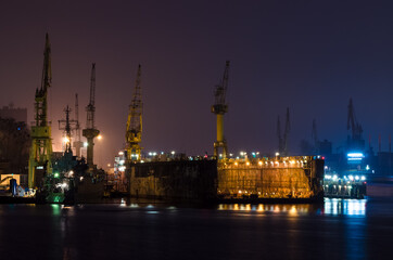 SHIPYARD - A floating repair dock and port cranes on the wharves

