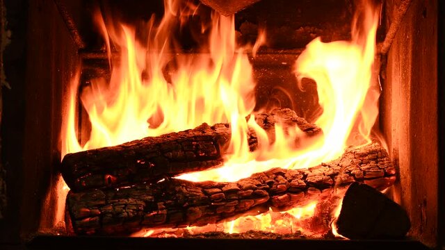 4K Warm cozy burning fire in a brick fireplace, close-up shot.