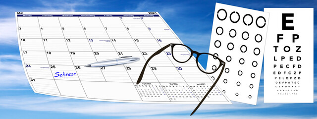 Kalender mit Sehtest und Brille und Kugelschreiber auf Himmel Hintergrund, Terminvergabe