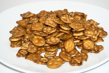 Salty biscuit cracker on a white plate on a white background