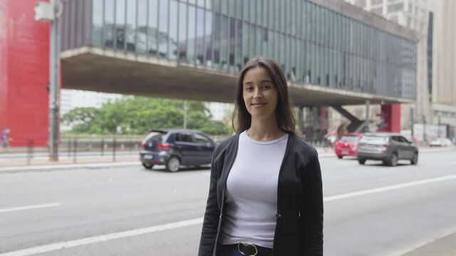 Portrait of beautiful white woman smiling at camera looking confident. Paulista Avenue in Brazil. Urban city background. Real people series
