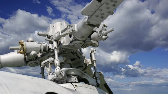 Details of the rotor and part of the body of modern military helicopters closeup, against the moving clouds    