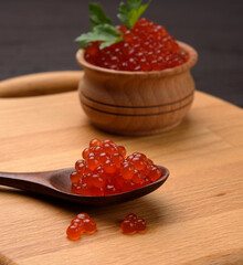 fresh grainy red chum salmon caviar in a wooden spoon