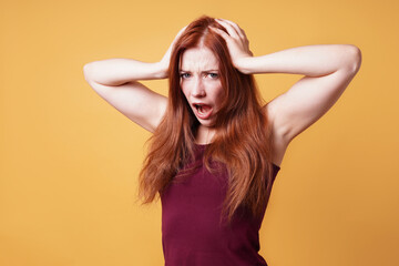 frustrated angry young woman holding her head screaming