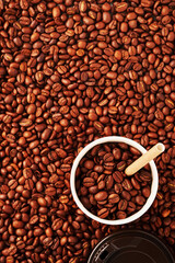 Grains of coffee drink and pieces of cane sugar in zero waste paper cup on grains background. Plastic free concept. Selective focus.