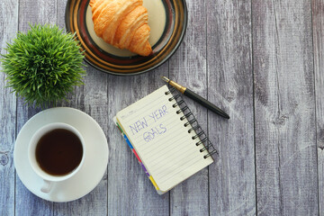 top view of new year goals text on notepad.