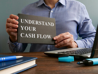 Man shows Understand your cash flow sign on the page.