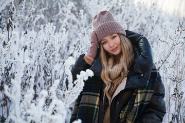 beautiful young woman in plaid blanket  smiles and laughs on a winter walk