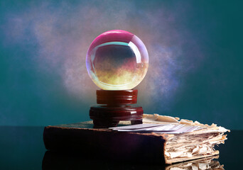 Spell book, crystal ball of fortune teller and cards on table