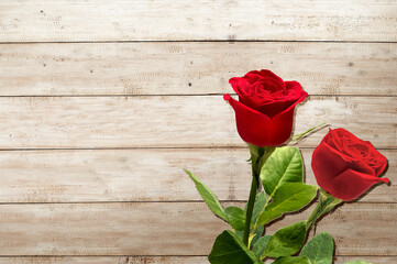 Fototapeta na wymiar Red roses on wooden table background