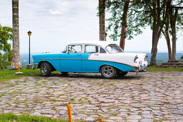 baby blue and white classic car in a park in cuba havana