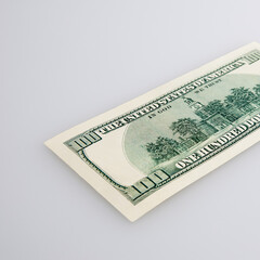 One hundred dollar cash bill on a light background.