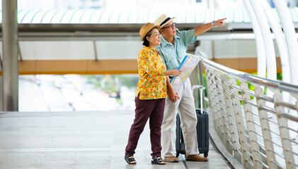 Travel and tourism concept.Asian Senior couple traveling happy excited tourists at the city