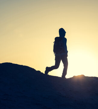 Backpacker hking on sunset desert