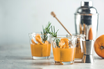 Fototapeta premium rosemary simple syrup or homemade whiskey sour cocktail drink with orange and rosemary. Decorate orange peel. Light concrete surface