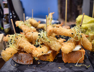 Pinchos y tapas de langostinos con crujiente rebozado sobre tacos de pan.jpg