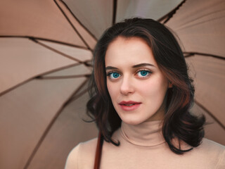 Woman under an beige umbrella