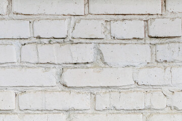 Old dirty painted white brick wall background, grungy texture. Building facade outside close-up