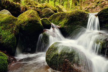 Wasserfall mit großen Steinen mit Moos