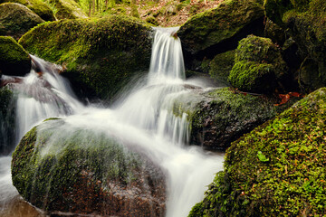 Wasserfall mit großen Steinen mit Moos