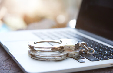 Cyber crime concept with Police handcuff on notebook keyboard