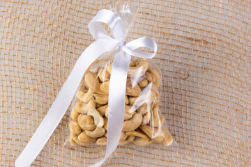cashew nuts in a gift transparent package on sacking on a white background