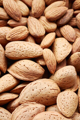 Close up picture of raw almonds in shell and shelled, selective focus.