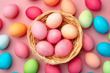 Naklejka na ściany i meble Painted Easter eggs in decorative nest on pink background