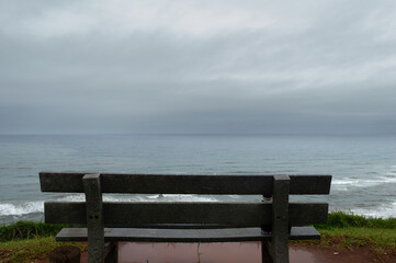 Fototapeta na wymiar Empty bench front the sea, back view