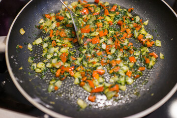 Frying pan on stove with pepper and mushrooms, closeup