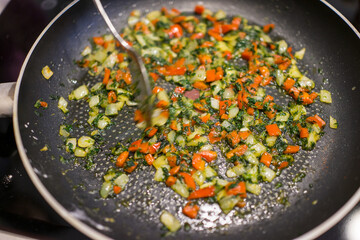 Frying pan on stove with pepper and mushrooms, closeup