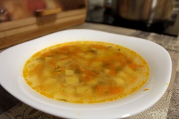 
A plate of chicken soup with carrots