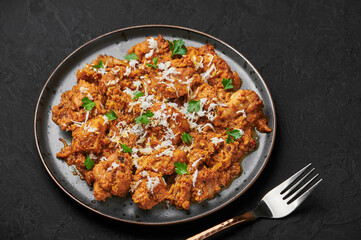 Mangalorean Chicken Sukka on black plate on dark slate table top. Indian cuisine coconut curry dish. Asian food and meal