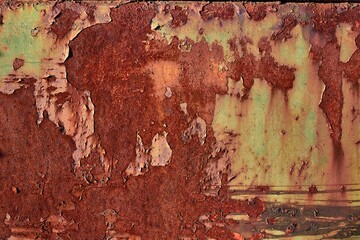 Texture of a rusty stained metal gate with paindwork peeling off