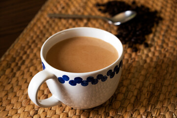 Hot coffee and coffee beans on the wooden table